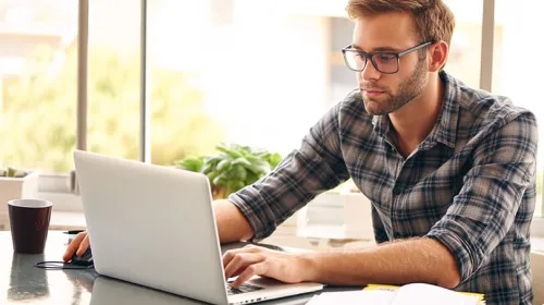 A man researching an SBIC on his laptop.
